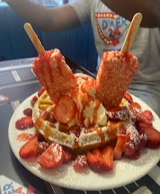 Strawberry Ice Cream Waffle Delight topped with fresh strawberries and two strawberry ice cream bars at Diner 24 NYC