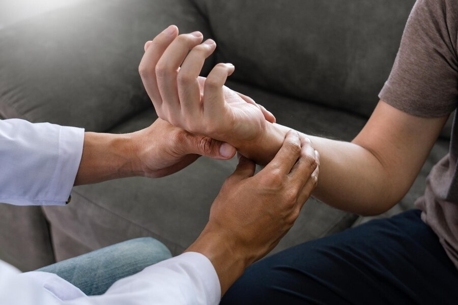 Cropped hand of physical therapist assisting patient in medical clinic